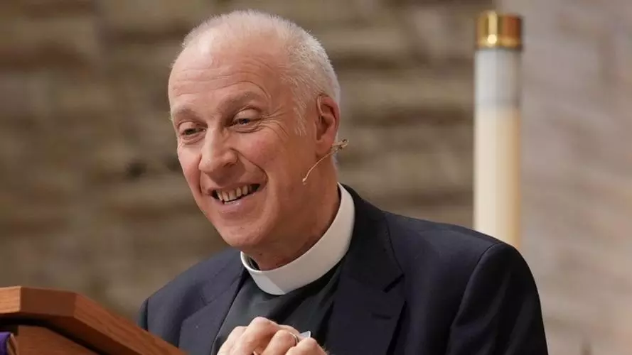 An image of MichaeL Lloyd standing at a lectern preaching