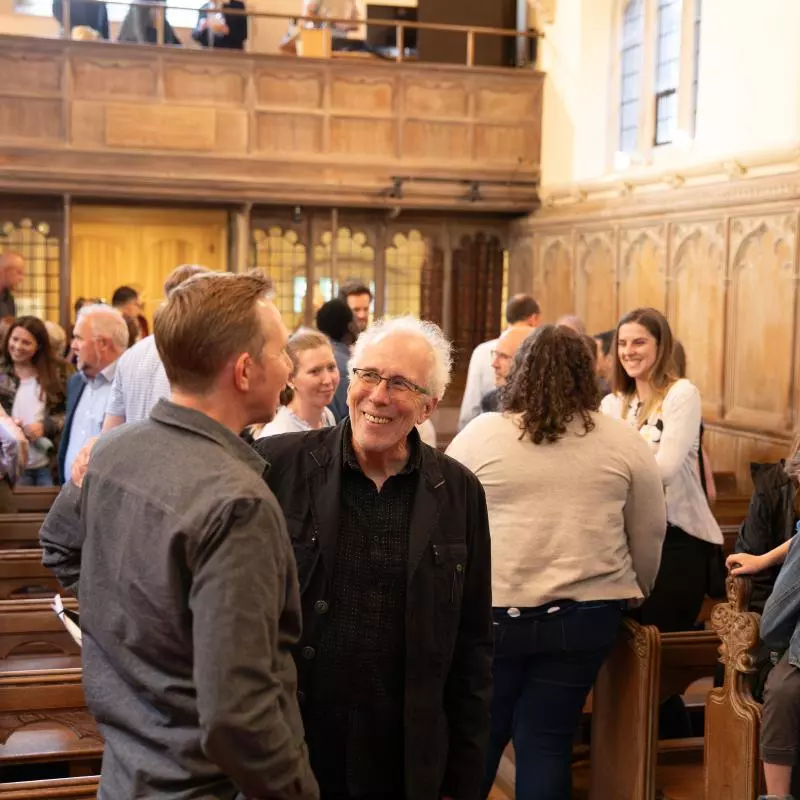 Groups of friends talking in the pews of Wycliffe's chapel